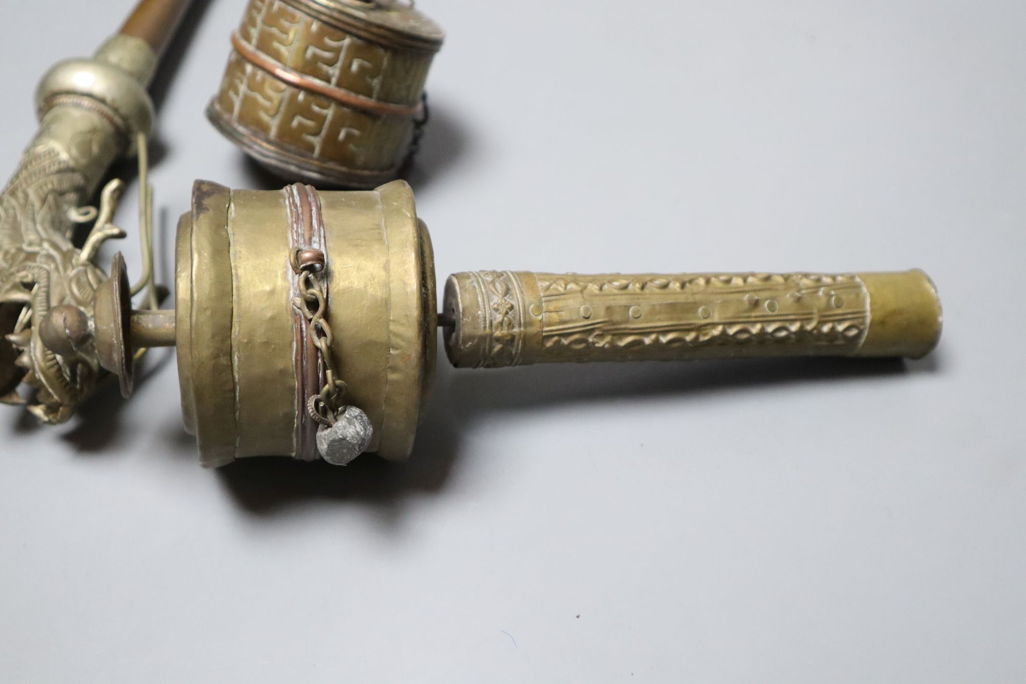 A Himalayan Buddhist brass trumpet and two prayer wheels